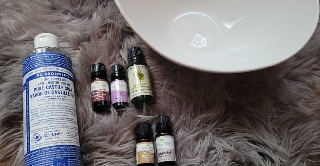 alt="essential oil bottles next to a bowl for hand soaking"